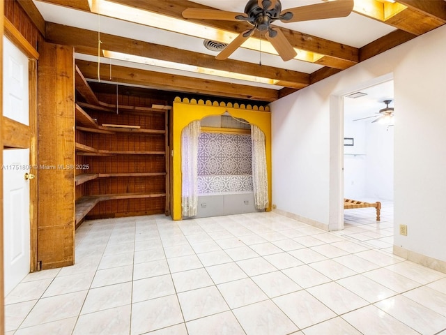 empty room with beamed ceiling, visible vents, light tile patterned floors, baseboards, and ceiling fan