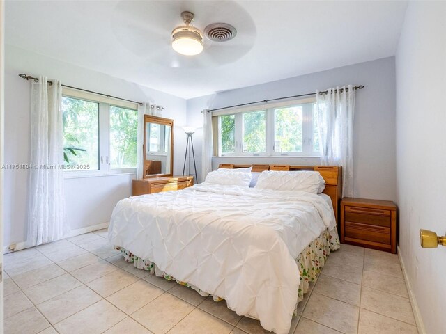 bedroom featuring light tile patterned flooring, visible vents, a ceiling fan, and baseboards