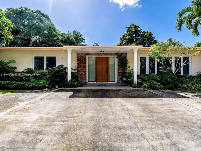 view of front of home featuring brick siding and stucco siding