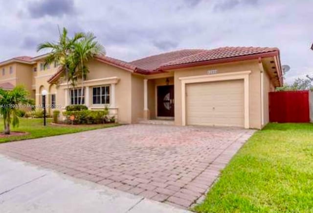 mediterranean / spanish home featuring a tiled roof, decorative driveway, a garage, and stucco siding