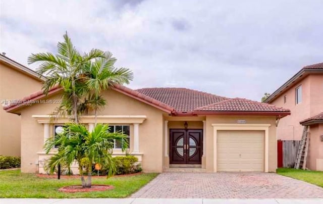 mediterranean / spanish-style house with stucco siding, a tiled roof, decorative driveway, and a garage