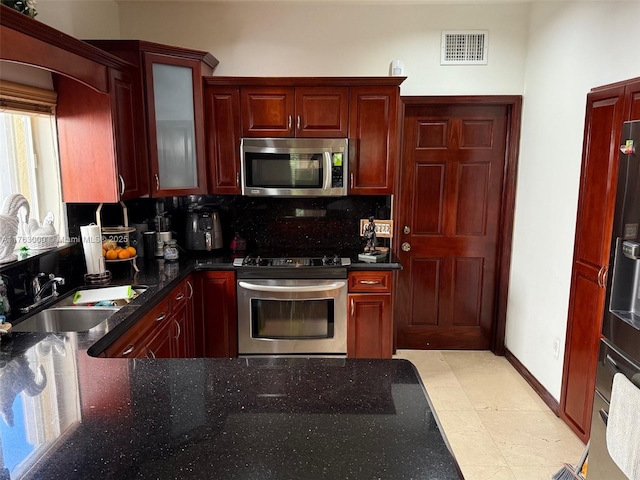 kitchen featuring visible vents, backsplash, dark brown cabinets, appliances with stainless steel finishes, and a sink