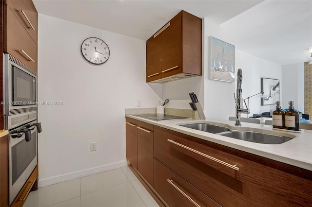 kitchen with oven, built in microwave, light countertops, modern cabinets, and a sink