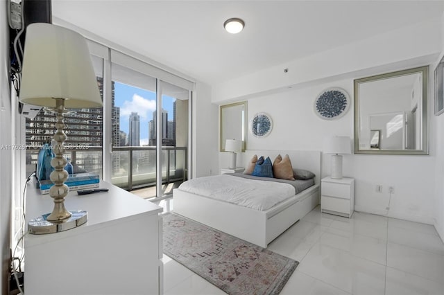 bedroom with a wall of windows, a view of city, and access to outside