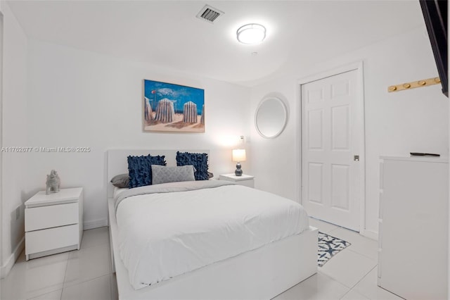 bedroom featuring light tile patterned floors, visible vents, and baseboards