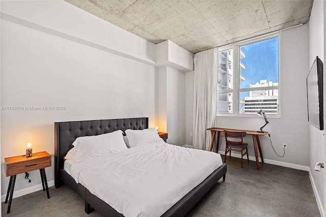 bedroom with baseboards and concrete floors