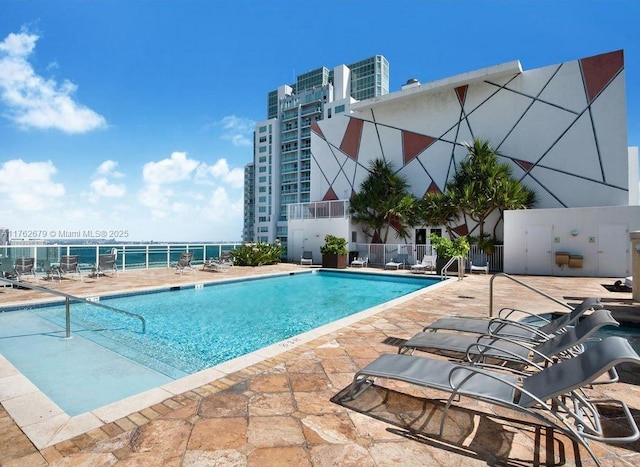 community pool featuring a patio area, central air condition unit, and fence