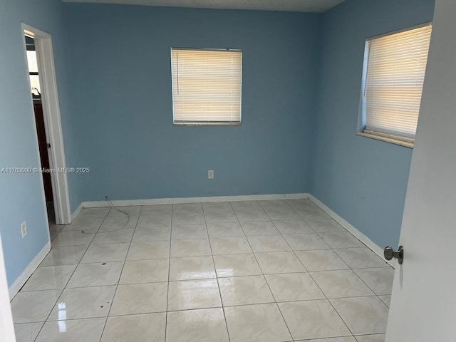 empty room with plenty of natural light and baseboards