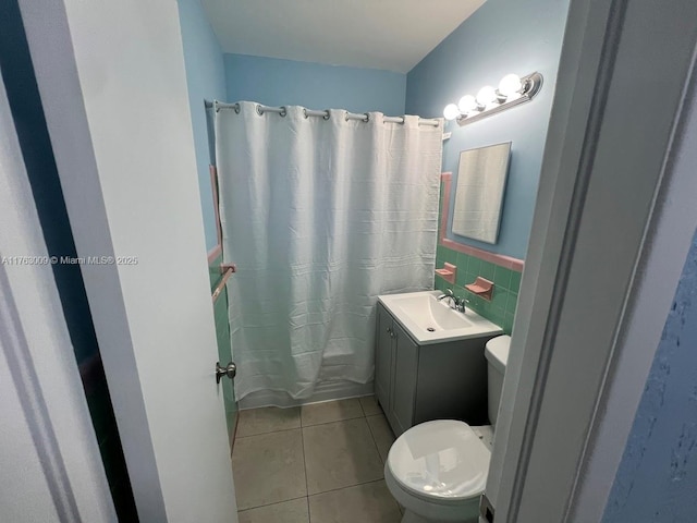 full bathroom with vanity, tile patterned flooring, shower / tub combo, tile walls, and toilet