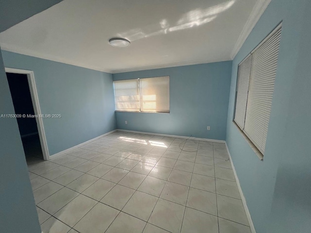 spare room featuring light tile patterned flooring, baseboards, and ornamental molding