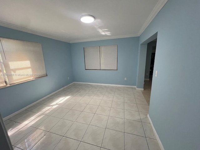 unfurnished room with light tile patterned flooring, baseboards, and ornamental molding