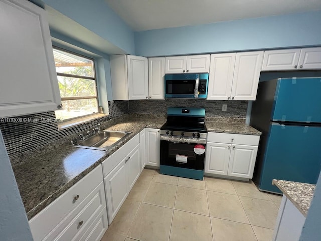 kitchen featuring a sink, tasteful backsplash, stainless steel appliances, white cabinets, and light tile patterned floors