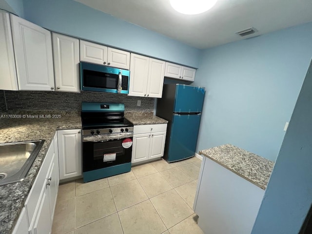 kitchen with visible vents, tasteful backsplash, white cabinetry, stainless steel appliances, and light tile patterned floors