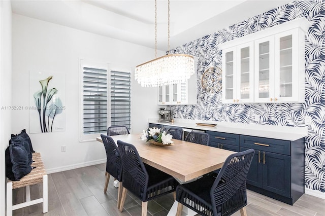 dining space featuring light wood-style flooring and baseboards