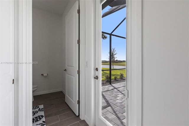 doorway with baseboards and wood tiled floor