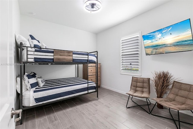 bedroom with baseboards and wood tiled floor