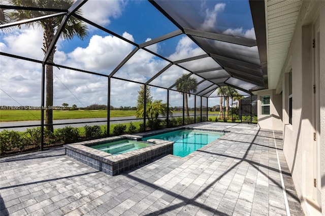 view of swimming pool with a patio area, glass enclosure, and a pool with connected hot tub