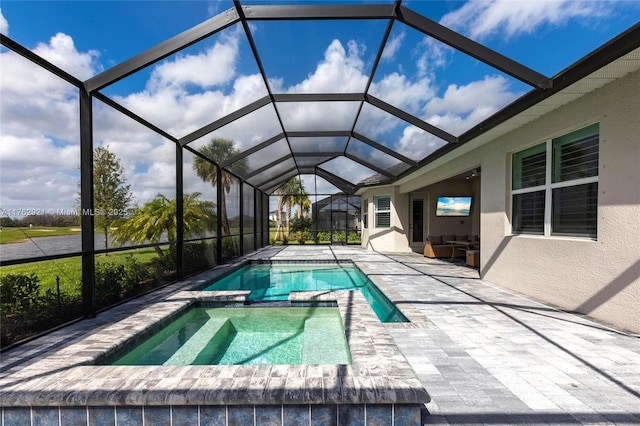 view of swimming pool featuring glass enclosure, a pool with connected hot tub, and a patio