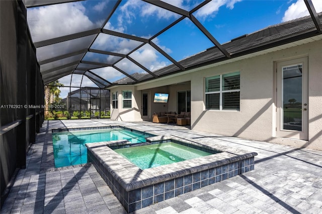 view of swimming pool featuring a pool with connected hot tub, a lanai, and a patio area