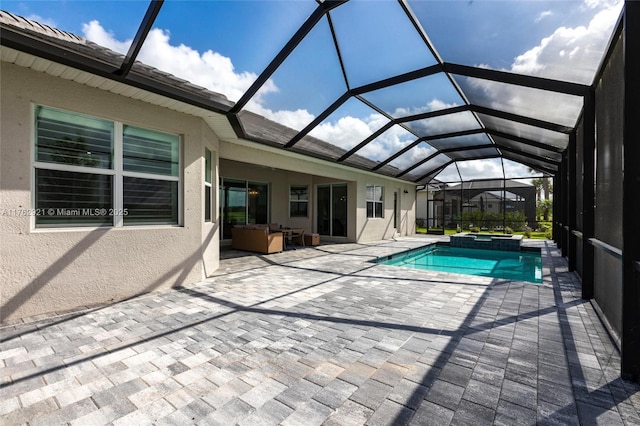 view of swimming pool featuring glass enclosure, a pool with connected hot tub, and a patio