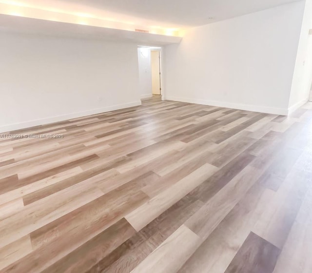 spare room with visible vents, baseboards, and light wood-style floors