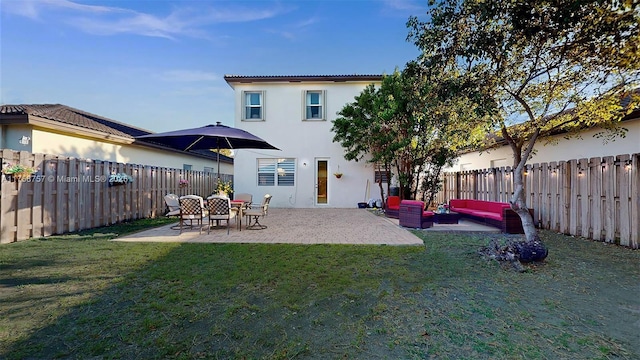 back of house with a patio, an outdoor living space, a fenced backyard, stucco siding, and a lawn