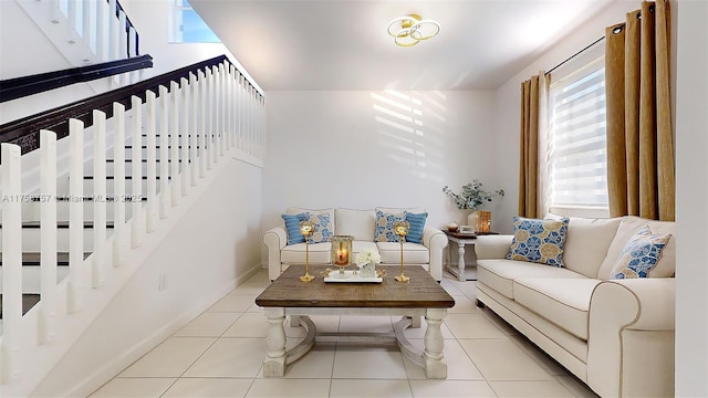 tiled living room featuring stairs and baseboards