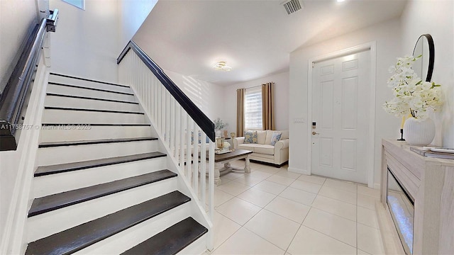 tiled entrance foyer with stairs and visible vents