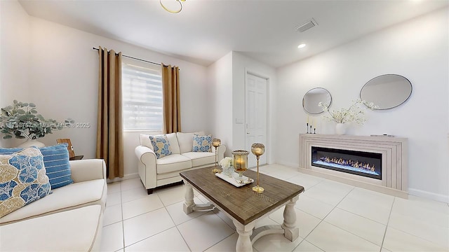 living area featuring visible vents, baseboards, light tile patterned flooring, recessed lighting, and a glass covered fireplace