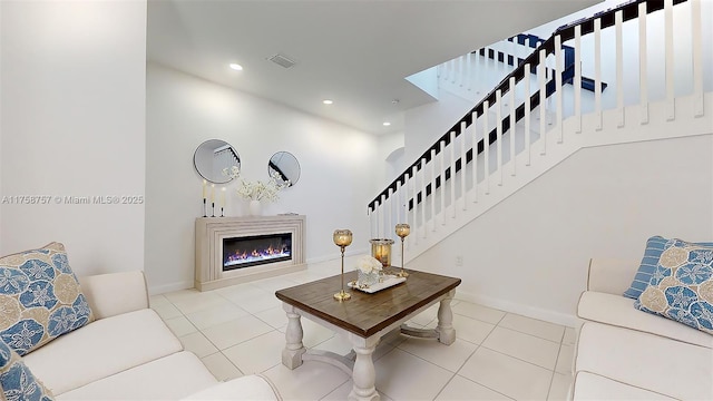 living room with tile patterned flooring, visible vents, stairway, recessed lighting, and a glass covered fireplace