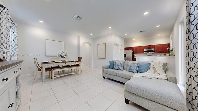 living room with visible vents, light tile patterned floors, recessed lighting, and arched walkways