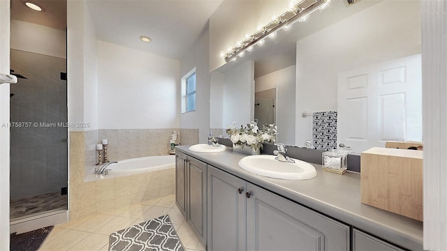 full bathroom with tile patterned floors, a bath, a stall shower, and a sink