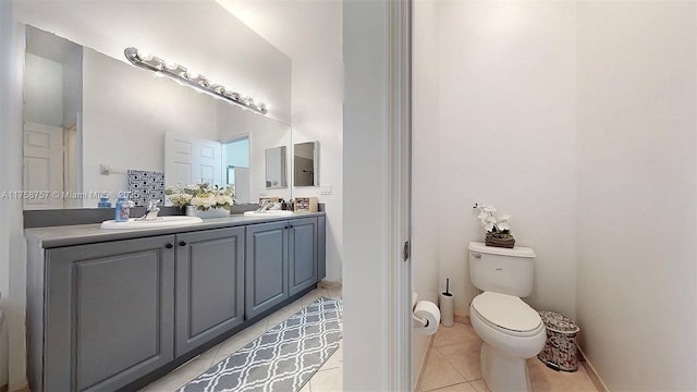 full bath featuring a sink, toilet, double vanity, and tile patterned floors