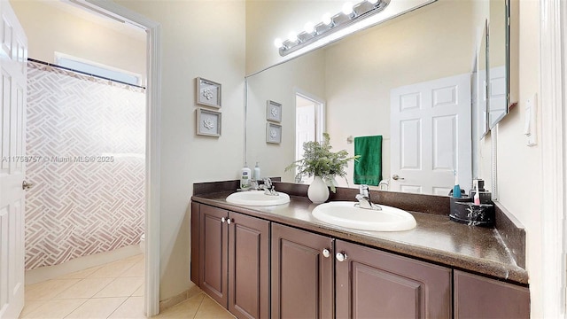 full bath with tile patterned flooring, double vanity, a healthy amount of sunlight, and a sink