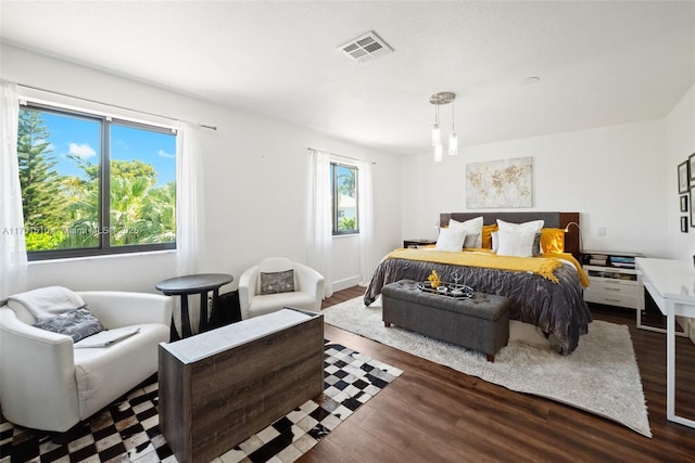 bedroom featuring wood finished floors and visible vents