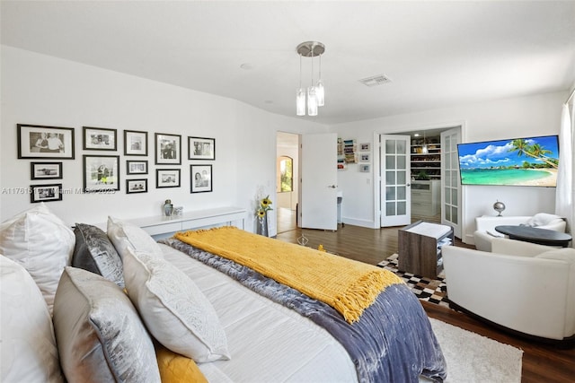 bedroom featuring visible vents and wood finished floors