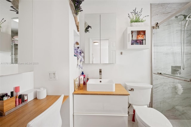 bathroom with vanity, a shower stall, and toilet