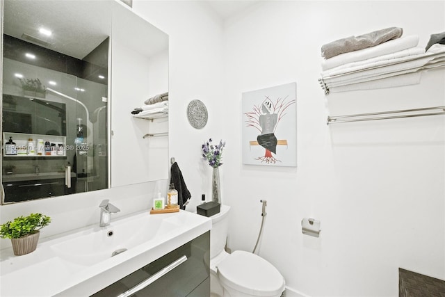 bathroom featuring a shower stall, vanity, and toilet