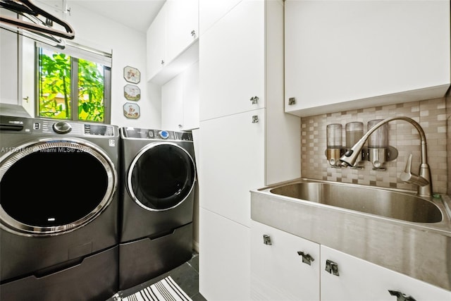 laundry room with washer and dryer, cabinet space, and a sink