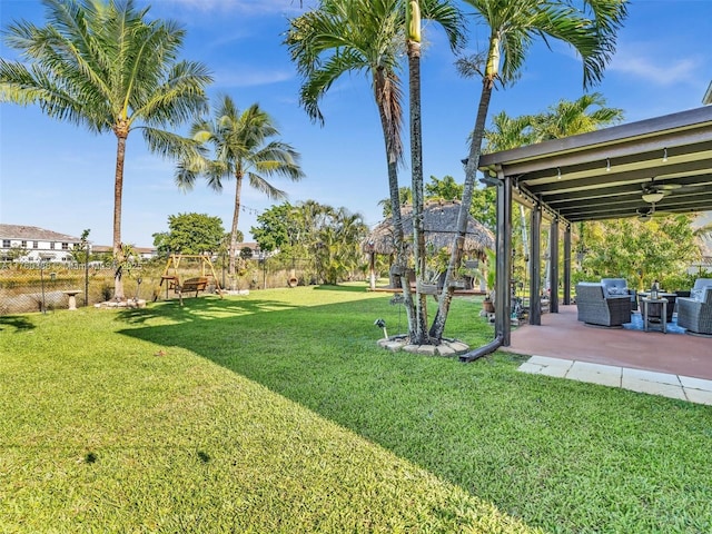 view of yard featuring an outdoor hangout area, a fenced backyard, a ceiling fan, and a patio area