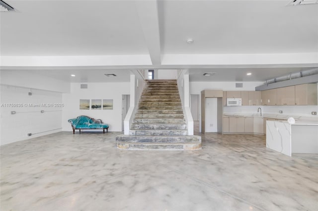 unfurnished living room with stairs, beam ceiling, visible vents, and concrete flooring