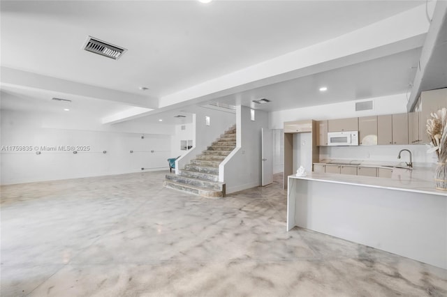 kitchen with visible vents, white microwave, concrete flooring, and open floor plan