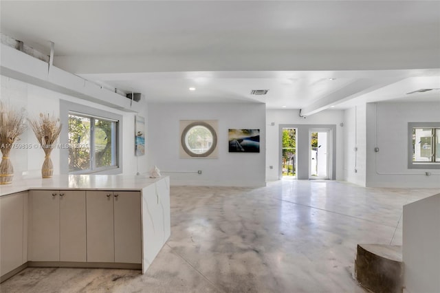 kitchen featuring beamed ceiling, finished concrete flooring, a healthy amount of sunlight, and open floor plan