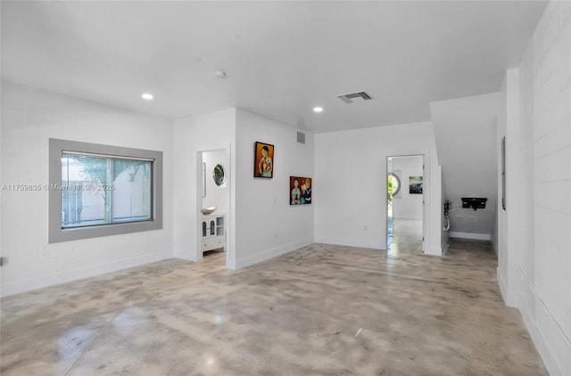 interior space featuring recessed lighting, visible vents, concrete floors, and concrete block wall