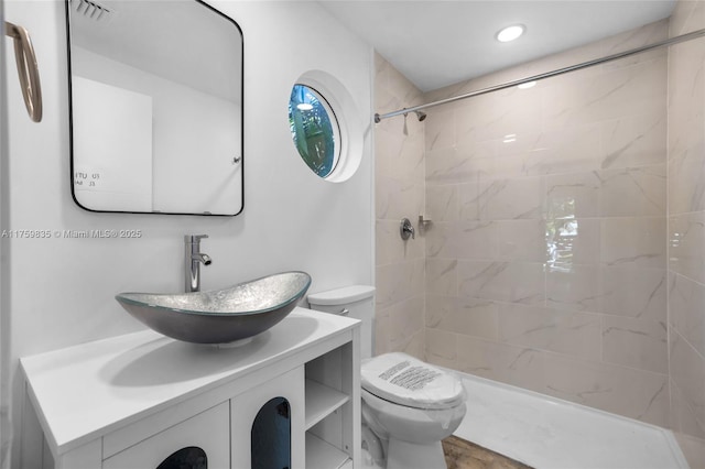 full bath with vanity, toilet, recessed lighting, and tiled shower