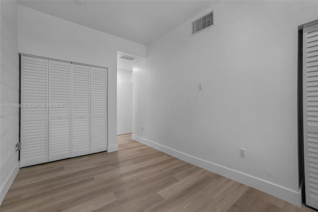 unfurnished bedroom with visible vents, baseboards, and wood finished floors