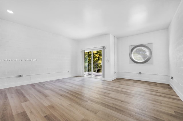 spare room featuring recessed lighting, wood finished floors, and baseboards