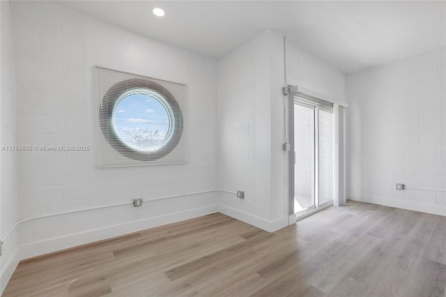 unfurnished room featuring recessed lighting, light wood-type flooring, and baseboards