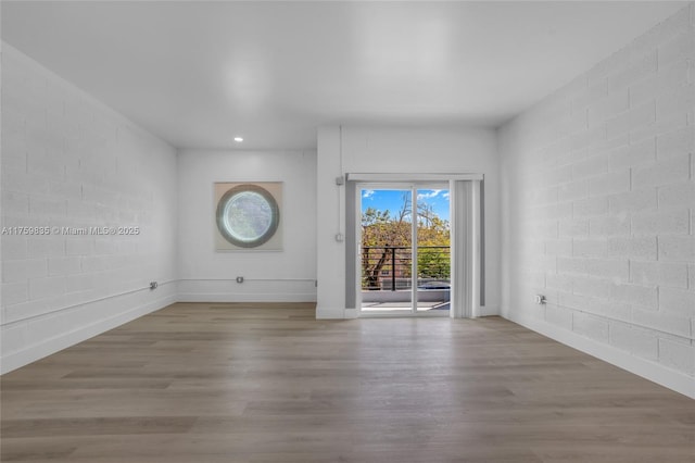 empty room with recessed lighting, baseboards, and wood finished floors