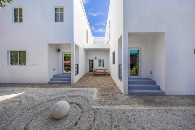 doorway to property with stucco siding and a patio area